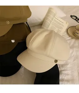 Détail de la casquette octogonale vintage avec une texture élégante et une boucle en métal.