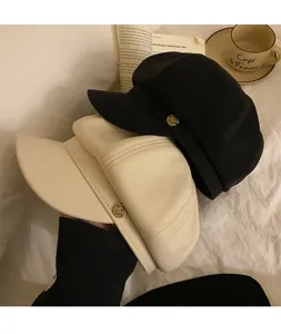 Vue de detail rapprochee de casquettes elegantes en melange de laine avec des boutons en metal.