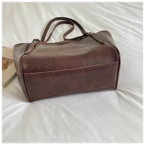 Detail van bruine gewaxte leren shopper, minimalistisch design en grote capaciteit voor dagelijks gebruik.