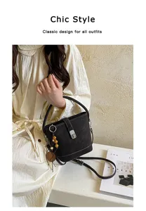 Vue détaillée du sac seau marron foncé chic avec verrou métallique et charmant pendentif.