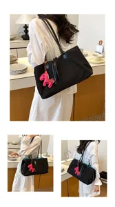Gedetailleerd overzicht van zwarte nylon tote tas met roze paardenbedel en blauwe voering.