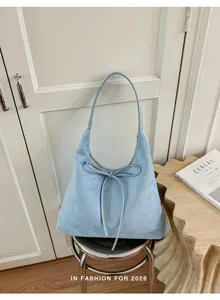 Lichtblauwe suade schoudertas voor dames, stijlvolle hobo shopper met strik en grote capaciteit.