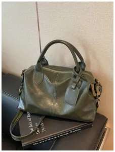 Gedetailleerd uitzicht van de donkergroene retro olieleer Boston handtas met duurzame textuur.