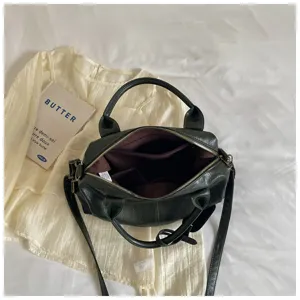 Gedetailleerd overzicht van de donkergroene vintage oliewas lederen boston handtas met vakken.