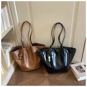Detailopname van casual zachte leren shopper tassen in bruin en zwart met ruime capaciteit.