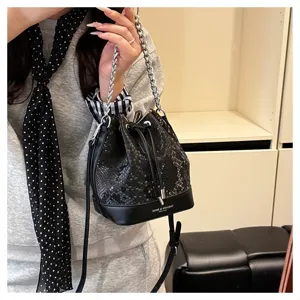 Vintage luxe slangenleer emmertas met metalen kettingriem, stijlvolle damestas voor dames.
