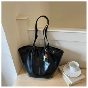 Gedetailleerd overzicht van de zwarte glanzende tote bag met mooie materiaaltextuur.