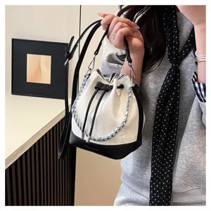 Detailopname van een chique emmertas met slangenhuidtextuur en zilveren ketting.