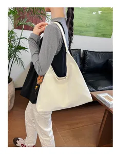 Detailansicht der großen weißen Umhängetasche in einer sehr eleganten Pendlerszene.