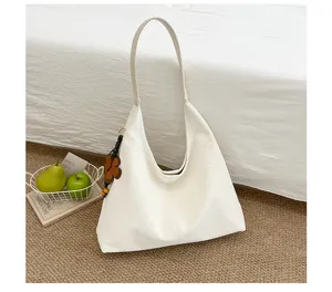 Detailansicht der eleganten weißen Schultertasche mit einem süßen Blumenanhänger Charm.