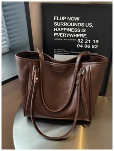 Donkerbruine PU lederen shopper tas close-up met fijne textuur en dubbele schouderbanden.