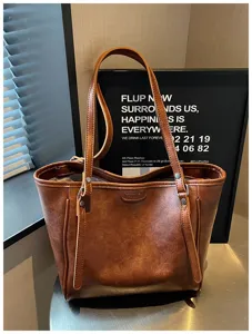 Gedetailleerd overzicht van de bruine olie-was lederen tote bag met textuur en grote capaciteit.