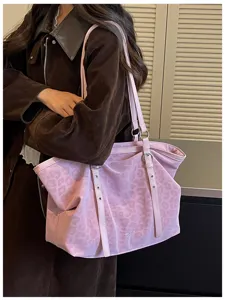 Detailansicht der stilvollen rosa Leopardenmuster Umhängetasche am Model, lässiger Stil.