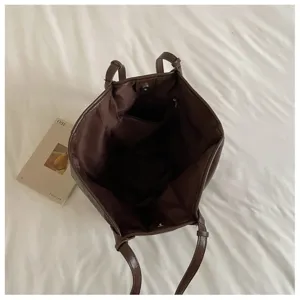 Gedetailleerd overzicht van de donkerbruine PU lederen shopper, ruim design met binnenzak.