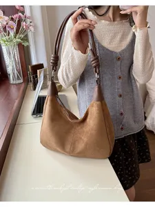 Bruine suède hobo tas detail, voorzien van uniek gevlochten handvat en metalen ritssluiting.