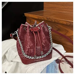 Vintage slangenprint bucketbag met ketting, chique rode lederen crossbody tas voor dames.