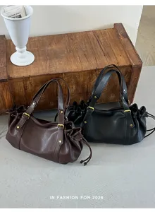 Detailansicht der stilvollen Plissee PU Leder Umhängetasche mit Schnalle und Kordelzug.