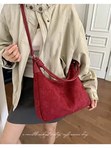 Gedetailleerd overzicht van deze rode suède hobo schoudertas met stijlvol geknoopt handvat.