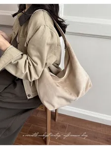 Suède schoudertas met zachte textuur, minimalistisch slouchy design en handige ritssluiting.
