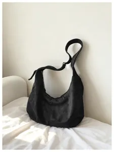 Schwarze Wildleder-Schultertasche Detailansicht, minimalistischer Hobo-Style weicher Stoff.