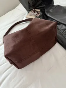 Bruine suede schoudertas detailweergave, zachte textuur, grote capaciteit voor dagelijks.