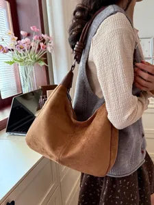 Bruine suède hobo schoudertas voor dames, zachte slouchy onderarmtas met stijlvolle knoopriem.