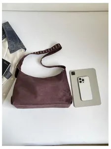 Detailansicht einer eleganten Retro-Wildledertasche mit Nieten, geräumig und schick.
