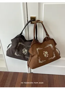 Gedetailleerd overzicht van vintage geborduurde tote tas met prachtig bloemmotief en inhoud.