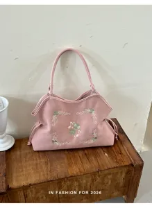 Gedetailleerd uitzicht op de roze retro tote tas met groene klaver en muzieknoot borduurwerk.