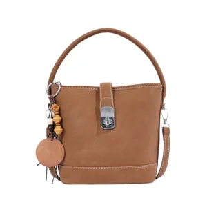 Élégant sac seau en cuir marron pour femmes avec poignée et breloque en perles de bois.