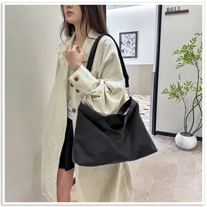 Gedetailleerd overzicht van zwarte canvas tote tas, casual grote schoudertas voor dagelijks.