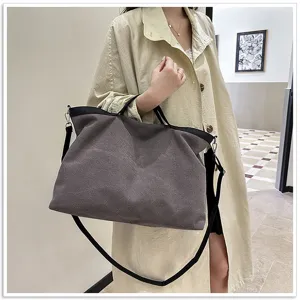 Detailweergave van de canvas tote tas met donkergrijze stof en zwarte schouderbanden.