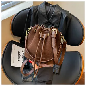 Gedetailleerd overzicht van retro bruine suède bucketbag, elegant crossbody ontwerp.