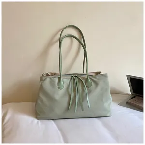 Minimalistische groene canvas tote tas detail, met dubbele schouderbanden en ruime binnenkant.