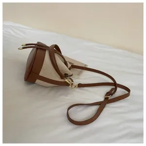 Retro bruine en beige emmertas detail weergave, canvas en PU leer contrast design met verstelbare riem.