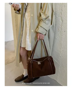 Gedetailleerd overzicht van retro bruine suède bowlinghandtas in minimalistische lookbookstijl.