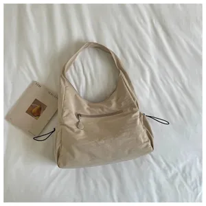 Vista dettagliata della borsa a spalla beige in tessuto, accessorio casual giornaliero.