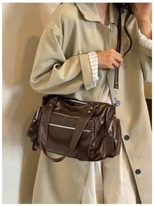 Gedetailleerd overzicht van retro bruine lederen schoudertas met zakken voor dames.