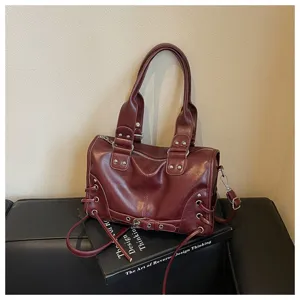 Nahaufnahme der dunkelroten Vintage Motorrad Boston Tasche mit Nieten und seitlicher Schnürung.