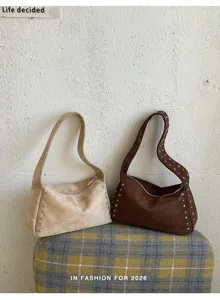 Detailansicht von Retro-Nieten-Wildleder-Umhängetaschen mit Metallbeschlägen in Beige und Braun.