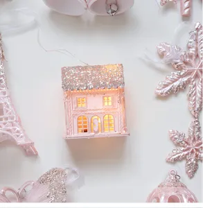 Pink glitter miniature house Christmas tree hanging ornament detail view with glowing light.
