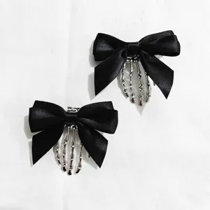 Gothic black bow hair clips featuring silver skeleton hand design, perfect for Halloween style.