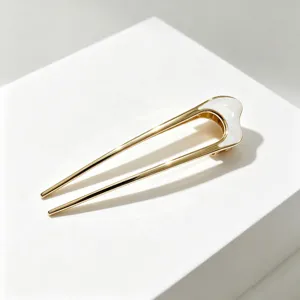 Épingle à cheveux dorée en forme de U avec émail blanc, accessoire élégant pour chignons chics.