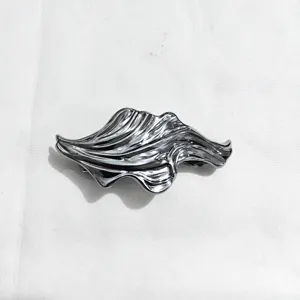 Close-up detail of the metallic wavy hair clip showcasing its unique fluid texture and shine.
