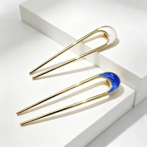 Vue de detail d'epingles a cheveux en metal en forme de U avec des accents en email.