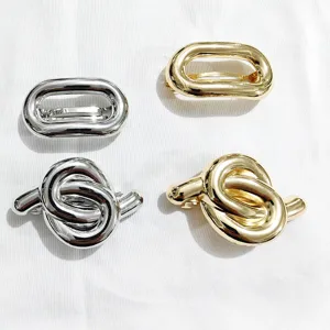 Fermagli per capelli metallici oro e argento con design ovali e nodi per uno stile chic.