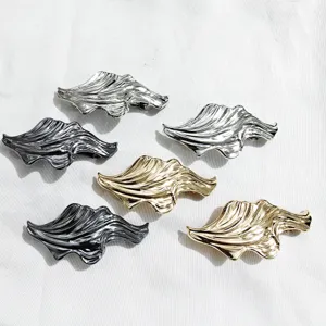 Detailed view of irregular metal wave hair clips featuring unique liquid flow design and finish.