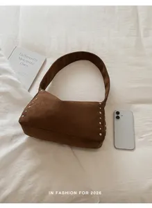 Detailansicht der retro braunen Wildleder Umhängetasche mit Nieten, schick und lässig für Alltag.
