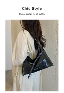 Detail shot of stylish black patent leather motorcycle shoulder bag with metal grommets.