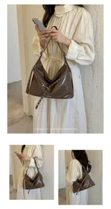 Retro brown patent leather shoulder bag for women, stylish hobo motorcycle bag with metal grommets.